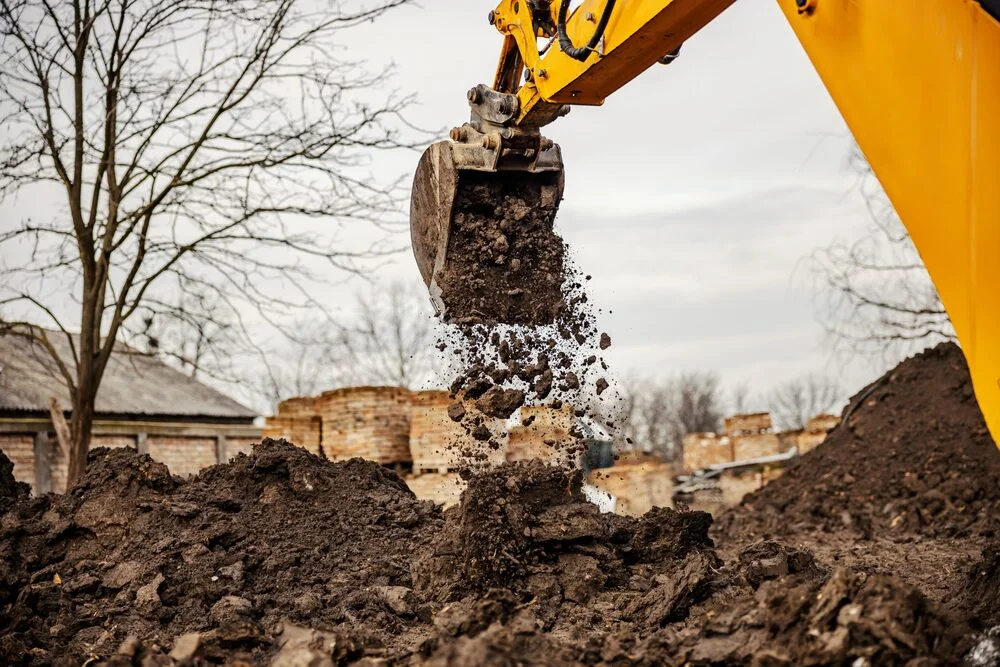 groundworkers london excavator dropping gravel on site